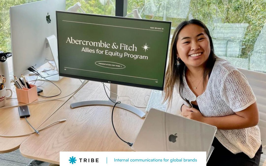 Rachel, an intern at Tribe, sitting next to a monitor where she gave a presentation on a program she joined.